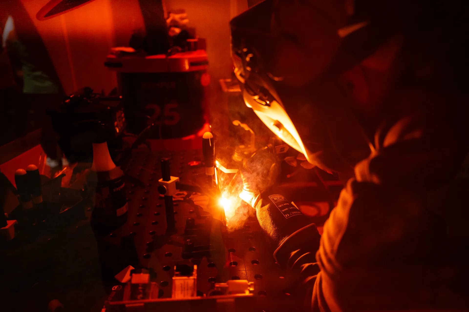 Welding in progress with dramatic red and orange lighting